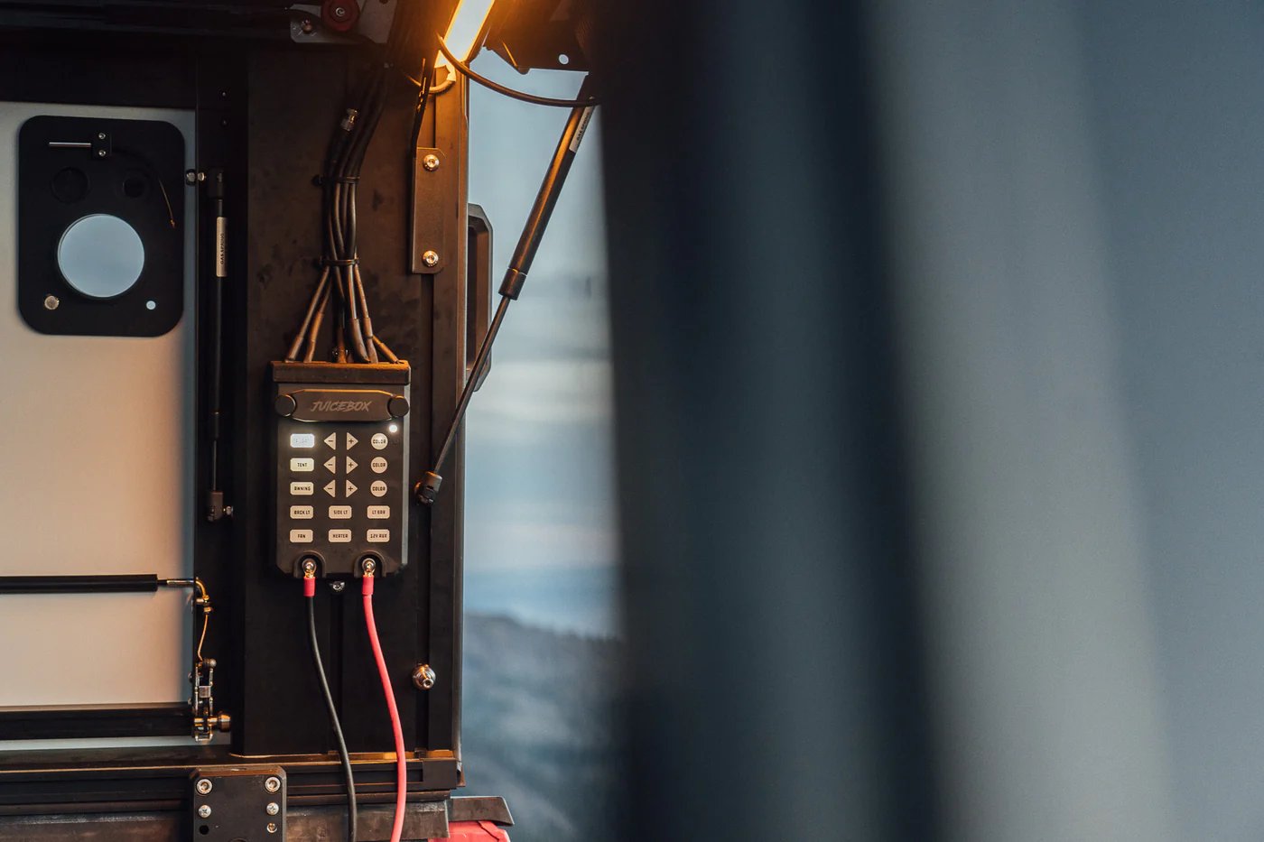 Custom off-road vehicle interior featuring a Niceebox control panel with multiple switches and red power cables, viewed from above with sky visible through windshield