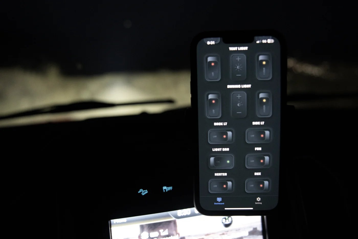 Smartphone displaying an off-road vehicle control app with lighting and accessory controls at night